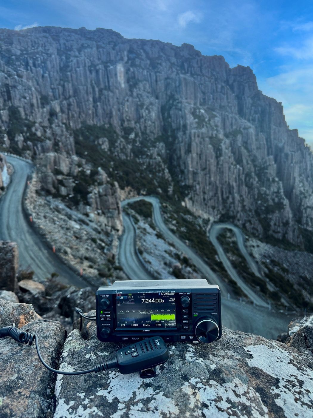 A mountain pass road with an iCOM transceiver in the foreground